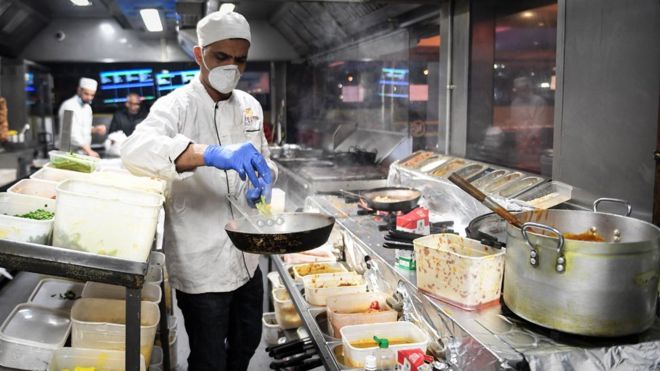Kitchen staff at the Kebabish Grill restaurant in Glasgow wear masks as they prepare foo