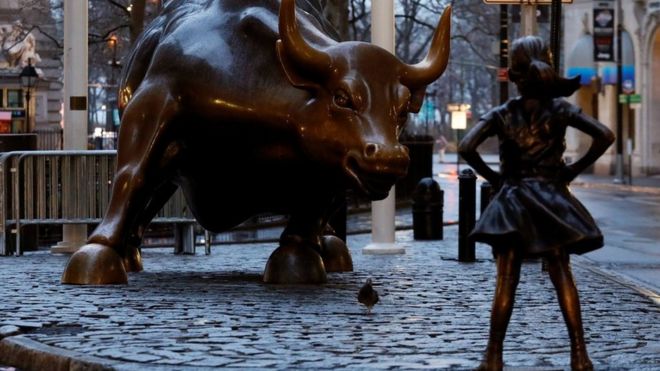 A statue of a girl facing the Wall St. Bull is seen, as part of a campaign by a US fund manager State Street to push companies to put women on their boards, in the financial district in New York