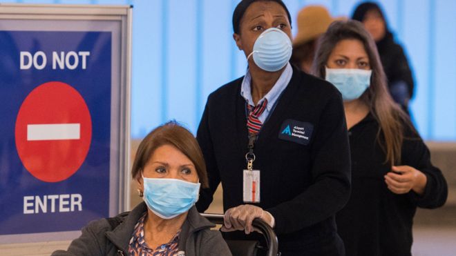People wear face masks after arriving at the LAX airport in Los Angeles on 5 March 2020
