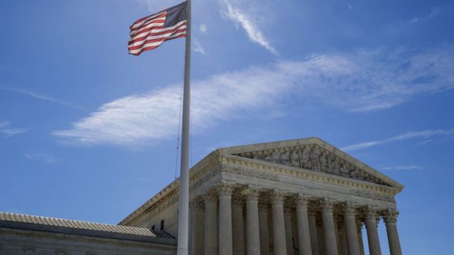 Флаг США развевается возле Верховного суда в Вашингтоне