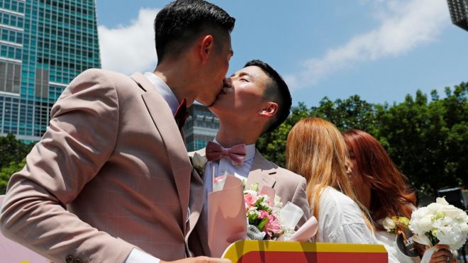 Couples kiss at a pro same-sex marriage party after registering their marriages in Taiwan