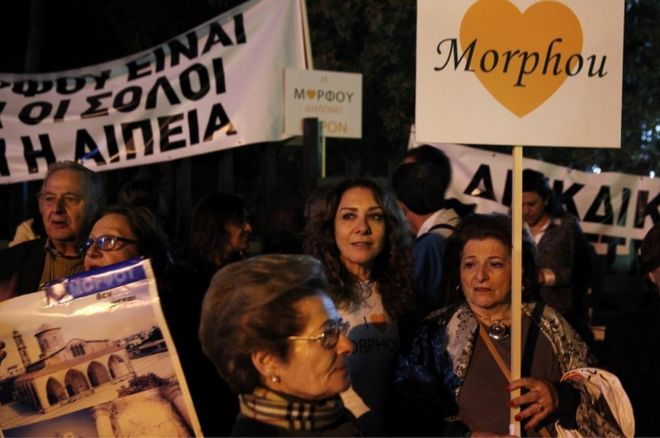 Перемещенные киприоты-греки из города Морфу проводят акцию протеста у президентского дворца в Никосии во время мирных переговоров по урегулированию давнего конфликта на этнически расколотом острове, Кипр
