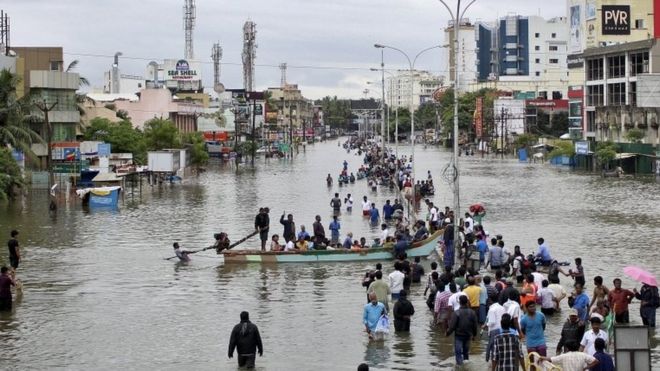 Люди путешествуют на лодке, когда они двигаются в более безопасные места по затопленной дороге в Ченнае, Индия, 2 декабря 2015 года.