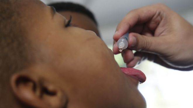 Menino recebendo vacina oral contra a poliomielite