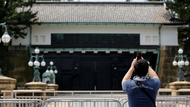 Мужчина фотографирует фото у Императорского дворца в Токио
