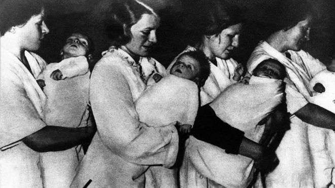 Alemanas llevando bebés de supuesta pureza aria en un Lebensborn.