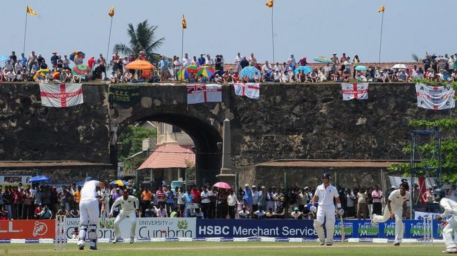 England cricket fans watch the second day of the opening Test match between Sri Lanka and England from the top of the 17th century Dutch fort overlooking Galle Stadium in Galle (27 March 2012)