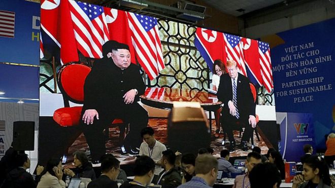 Journalists work next to a large screen displaying news reporting on the second US-North Korea Summit, at the international media centre, in Hanoi, Vietnam, 28 February 2019