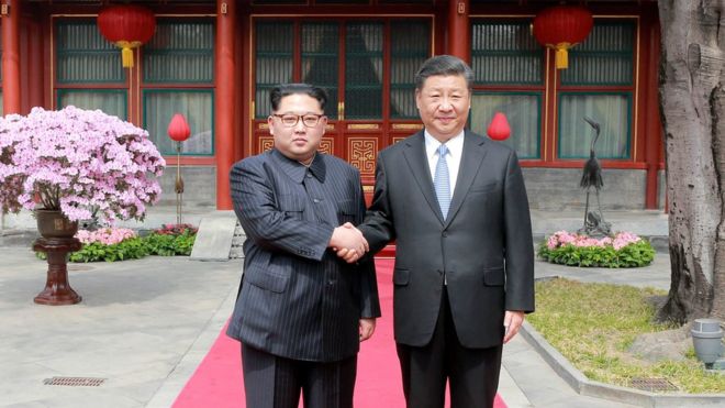 Северокорейский лидер Ким Чен Ын пожимает руку президенту Китая Си Цзиньпину, когда он совершил неофициальный визит в Пекин, Китай,