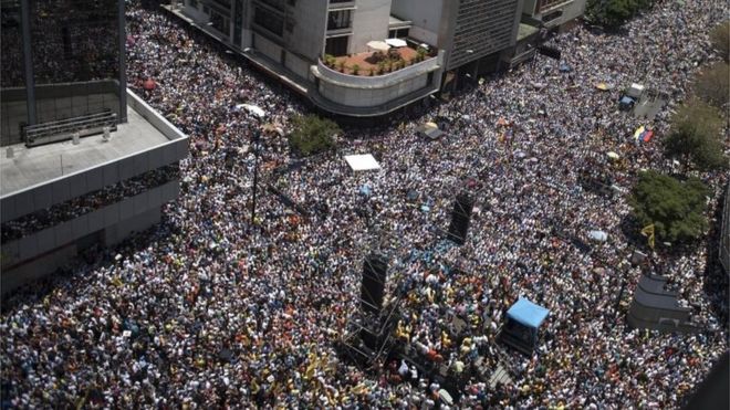 Тысячи демонстрантов протестуют против правительственного шествия президента Николая Мауро в Каракасе 8 апреля 2017 года.