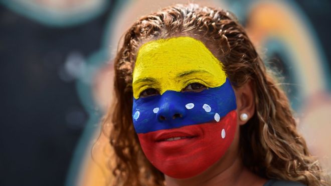 Mujer con el rostro pintado con los colores de la bandera de Venezuela