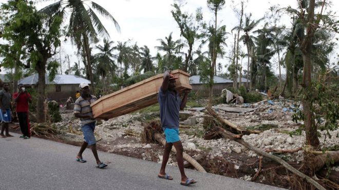 Men carry a coffin after Hurricane Matthew hit Cavaillon, Haiti