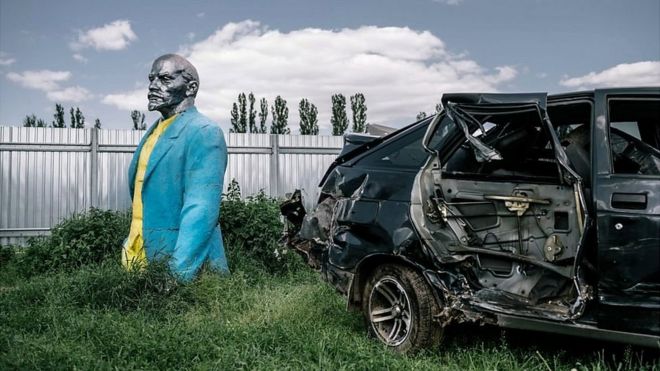 Una estatua de Lenin en un depósito de autos viejos