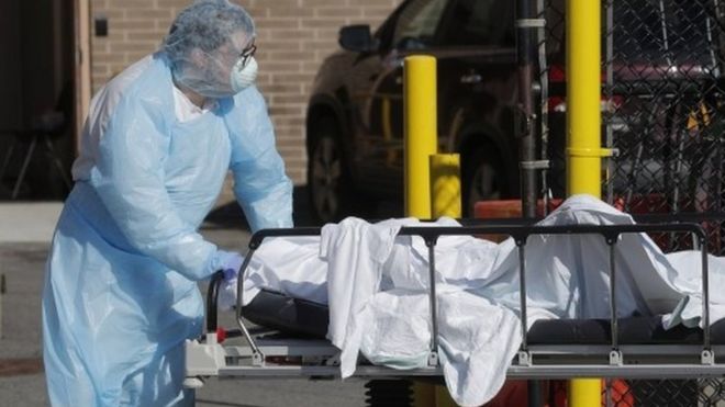 A healthcare worker wheels the body of a deceased person into a makeshift morgue near a hospital in New York. File photo