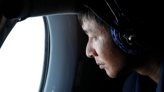 Военный офицер смотрит в окно во время поисково-спасательной операции на борту самолета, принадлежащего вьетнамским военно-воздушным силам, у острова Вьетнам Тхо Чу 10 марта 2014 года