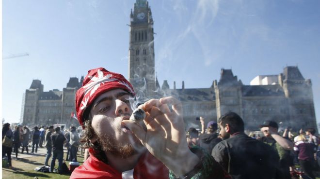 Мужчина курит марихуану во время ежегодного митинга 4/20 на Парламентском холме в Оттаве, Канада, 20 апреля 2016 года.