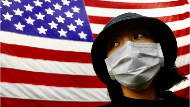 TAIPEI, TAIWAN - 2021/01/27: A Taiwanese woman seen next to a national flag of USA.