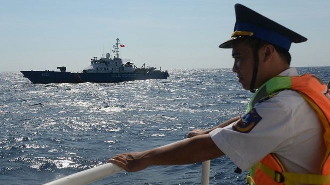 Một cảnh sát biển Việt Nam đăm đăm nhìn tàu hải cảnh Việt Nam di chuyển gần dàn khoan của Trung Quốc tháng Năm, 2014.