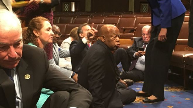 Фотография, показывающая членов Конгресса от демократов, в том числе от демократа Джона Льюиса (в центре), в сидячей демонстрации за голосование по мерам контроля над оружием, среда, 22 июня 2016 г.