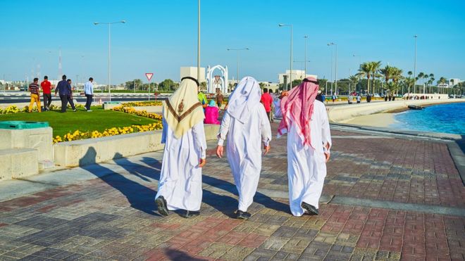 Люди идут по карнизу в Дохе (февраль 2018 года)