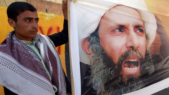 Йеменский протестующий держит фотографию шейха Нимра в 2014 году