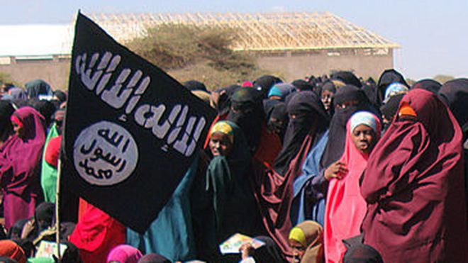 Women look at al-Shabab fighters following a demonstration