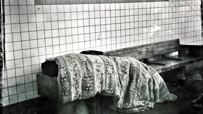 Una persona sin techo en el metro de Nueva York.