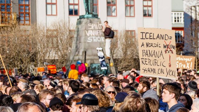 Люди собираются во время акции протеста на площади Austurvollur перед зданием исландского парламента в Рейкьявике, Исландия, 4 апреля 2016 года