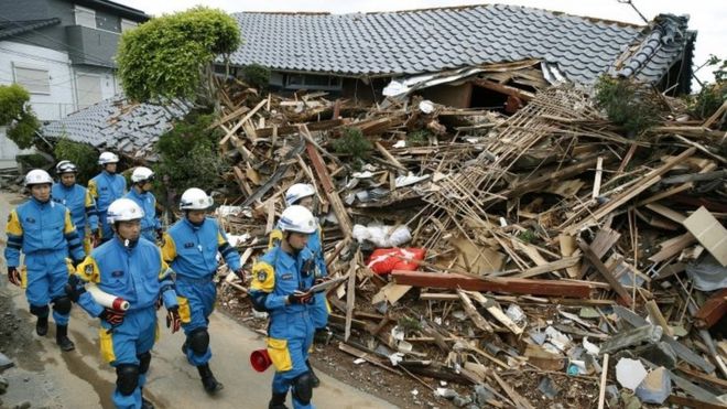 Сотрудники полиции осматривают ущерб в Машики, префектура Кумамото (17 апреля 2016 года)