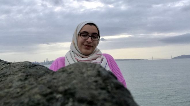 Изображение Sabreen Imtair, стоящего перед морем перед большой скалой
