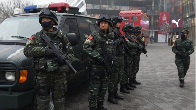 Armed police stand guard in the popular shopping and nightlife area of Sanlitun in Beijing on 26 December 2015.