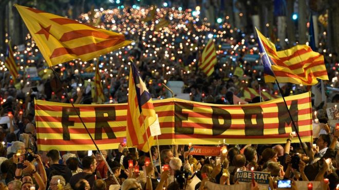 People attend a candle-lit demonstration in Barcelona against the arrest of two Catalan separatist leaders on October 17, 2017. C