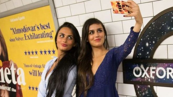 Dos jóvenes se hacen una selfie en el metro de Londres.