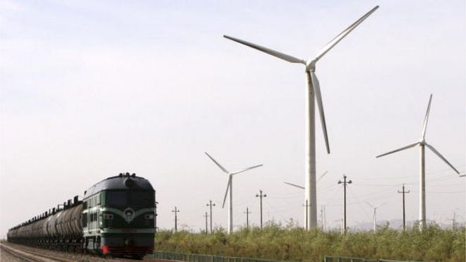 Поезд проезжает мимо ветровых турбин на ветряной электростанции в Дабанчен, Синьцзян-Уйгурский автономный район, Китай