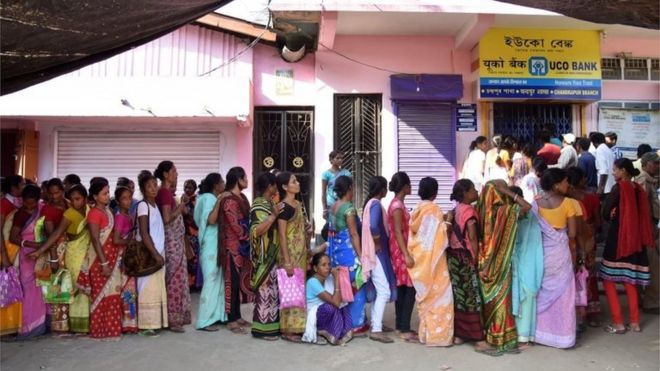 Индийские сельские жители ждут в очереди перед банком, чтобы внести и обменять 500 и 1000 рупий в деревне Чандрапур, примерно в 30 км от Гувахати 15 ноября 2016 года.