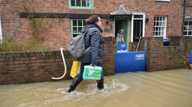 Женщина пробирается через наводнение в Тьюксбери, Глостершир