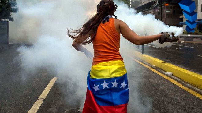 manifestante brasileña devuelve un gas.