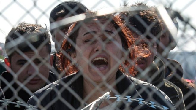 Женщина кричит и плачет на греческой стороне границы с Македонией