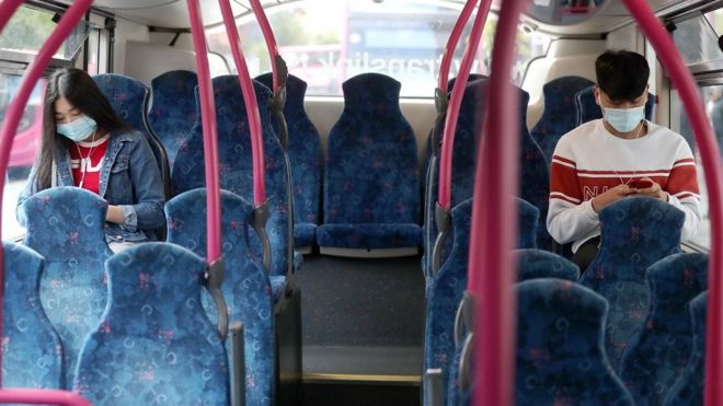 Пассажиры в защитных масках на борту автобуса в Белфасте