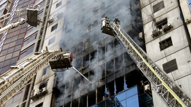 Пожарные пытаются потушить пожар, который вспыхнул в высотном здании в районе Банани Дакки, Бангладеш, 28 марта 2019 года