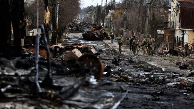 Soldiers walk past a destroyed Russian tank and armoured vehicles, amid Russia"s invasion on Ukraine in Bucha, in Kyiv region, Ukraine April 2, 2022.