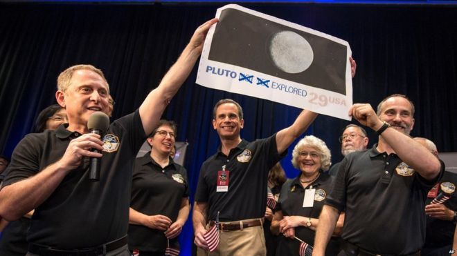 Ученые и инженеры задерживают увеличение почтовой марки США с изображением Плутона