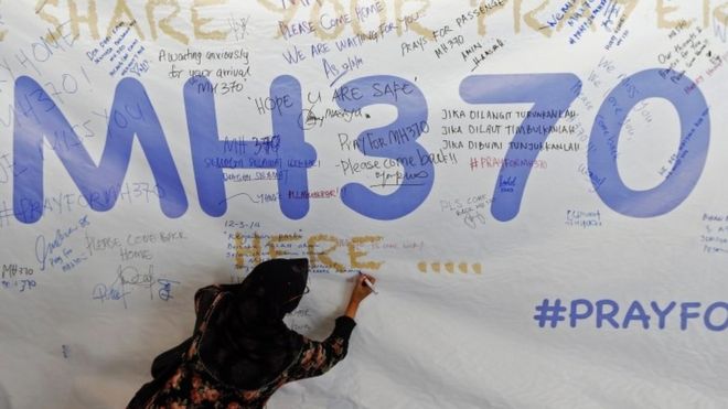 A woman writes on a message board after the disappearance of Malaysia Airlines flight MH370