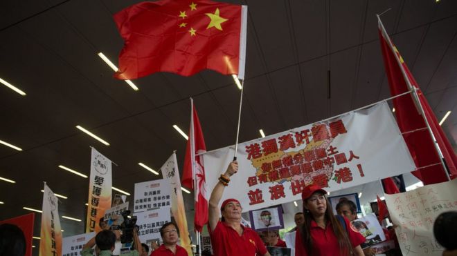Прокитайские сторонники развевают флаг Китайской Народной Республики во время акции протеста перед Законодательным советом в Гонконге, Китай, 19 октября 2016 года.