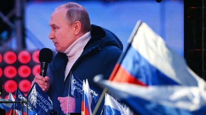 Tổng thống Nga Vladimir Putin xuất hiện trên màn hình khi ông có bài phát biểu trong buổi hòa nhạc đánh dấu kỷ niệm tám năm ngày Nga sáp nhập Crimea ngày 18 tháng 3 năm 2022