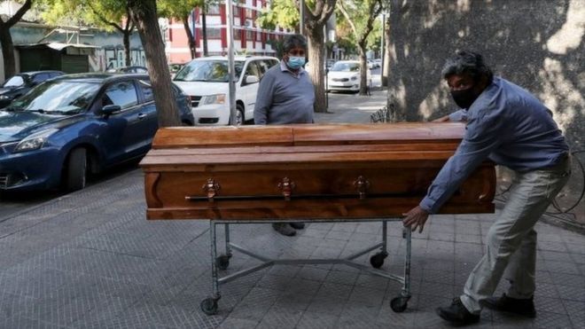 Funeral home workers move a casket outside a morgue at a hospital area, during the coronavirus disease (COVID-19) pandemic, in Santiago, Chile April 8, 2021