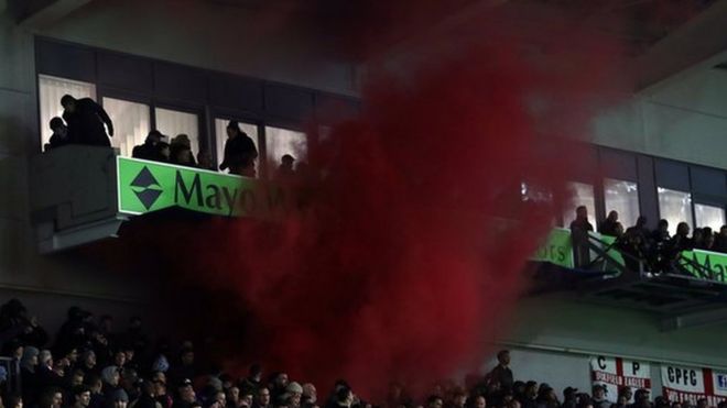 Вспышки испускаются фанатами Кристал Пэлас на стадионе Амекс
