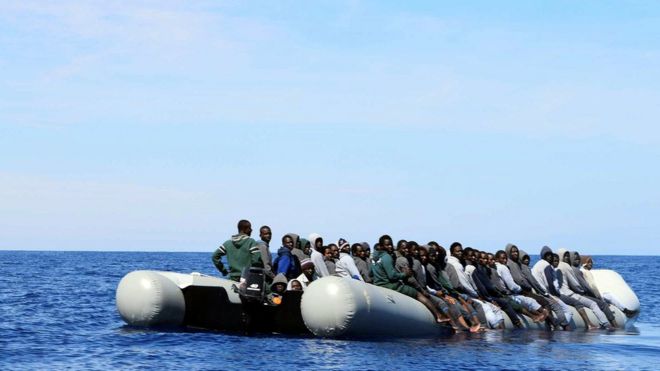 Мигранты сидят в лодке во время спасательной операции на итальянском военном корабле Грекале у побережья Сицилии