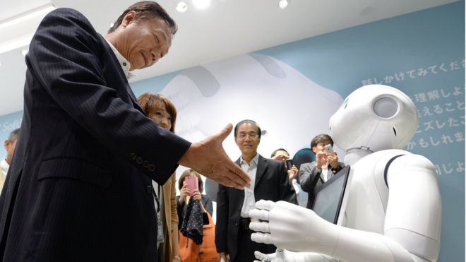 Терри Гоу (слева), председатель и генеральный директор тайваньской группы Foxconn Technology, пытается пожать руку гуманоидному роботу Pepper (справа), который совместно разработан японским оператором мобильной связи SoftBank и французским производителем гуманоидных роботов Alderbaran и произведен Foxconn. выставочный зал SoftBank в Токио, 6 июня 2014 г.