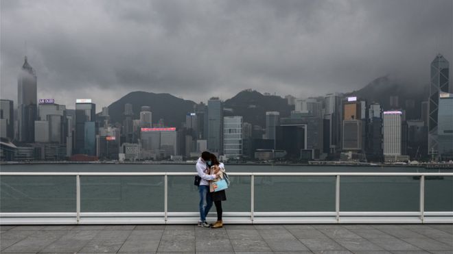 Пара стоит на смотровой площадке в Цим Ша Цуй в Гонконге 14 февраля 2020 года